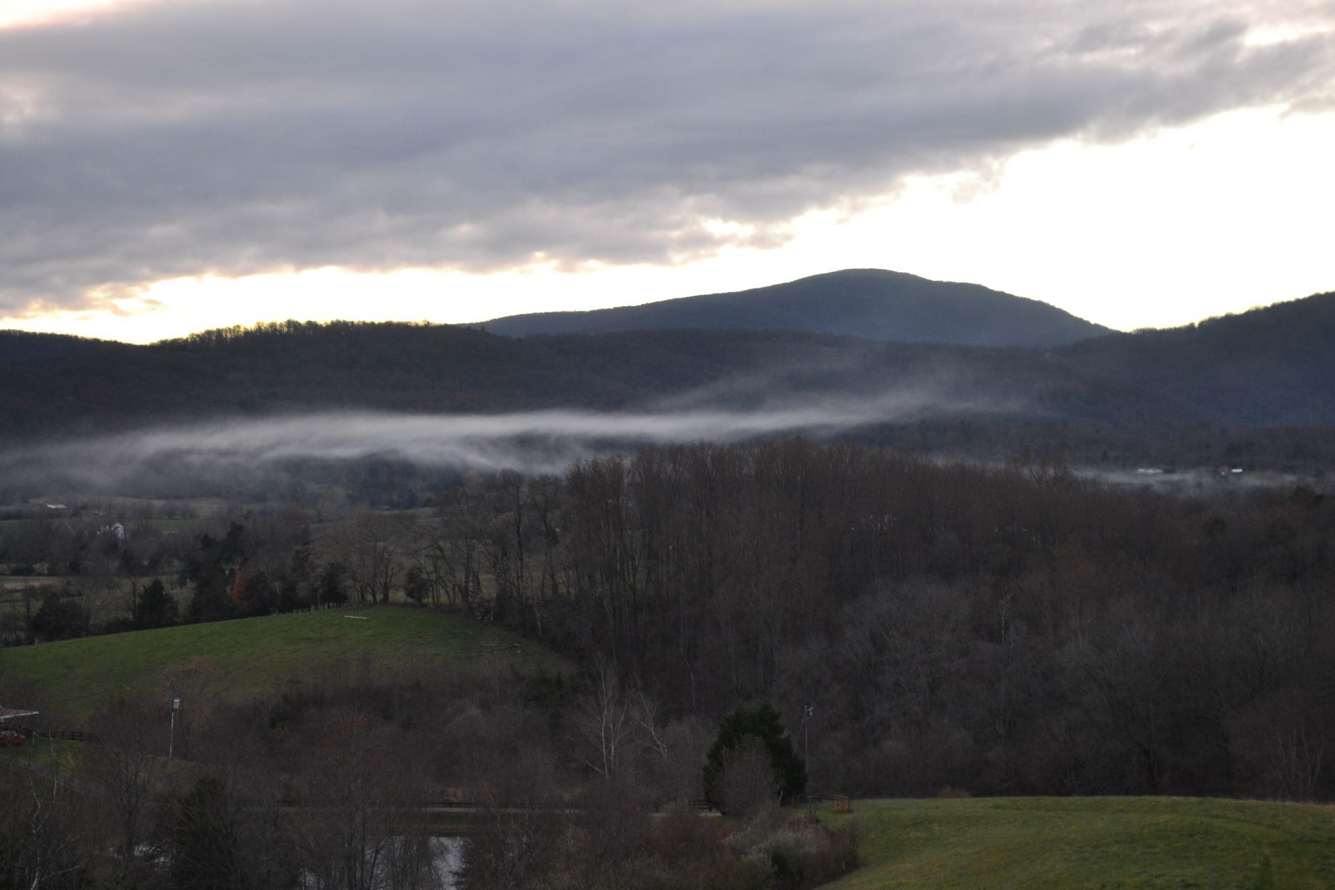 A foggy valley with mountains in the background