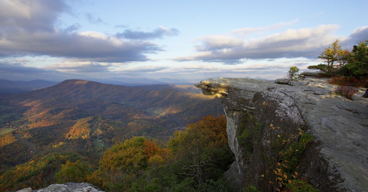 A view of a mountain range from the top of a cliff.