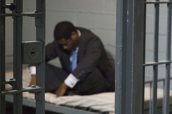 A man in suit inside the jail.