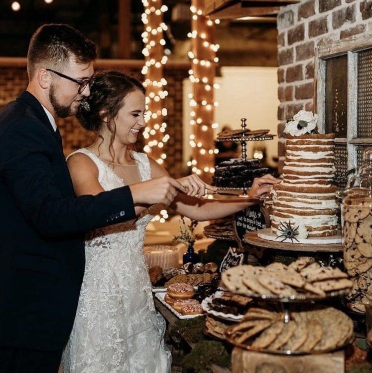 A bride and groom are cutting their wedding cake.