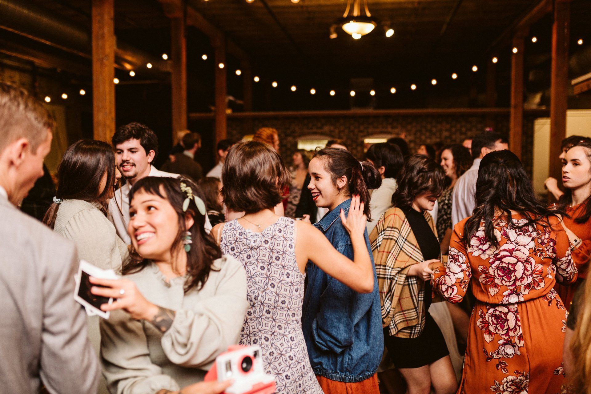 A group of people are dancing in a room at a party.