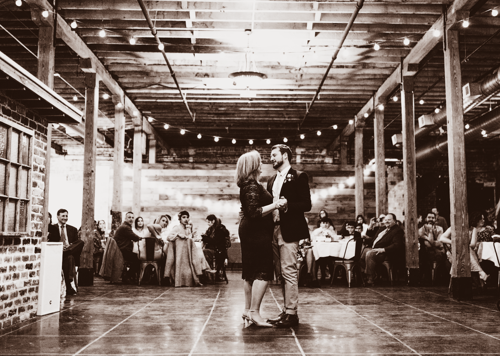 A black and white photo of a man and woman dancing on a dance floor.