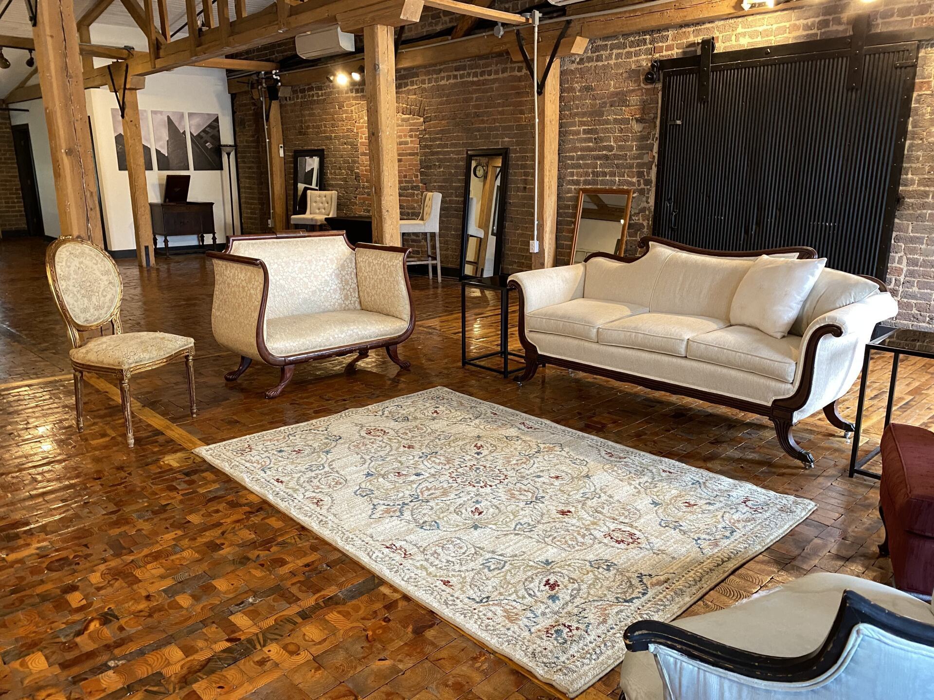 A living room with a couch , chairs , and a rug.