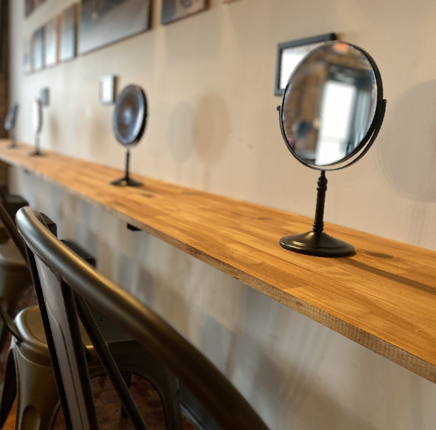 A mirror sits on a wooden shelf in a room