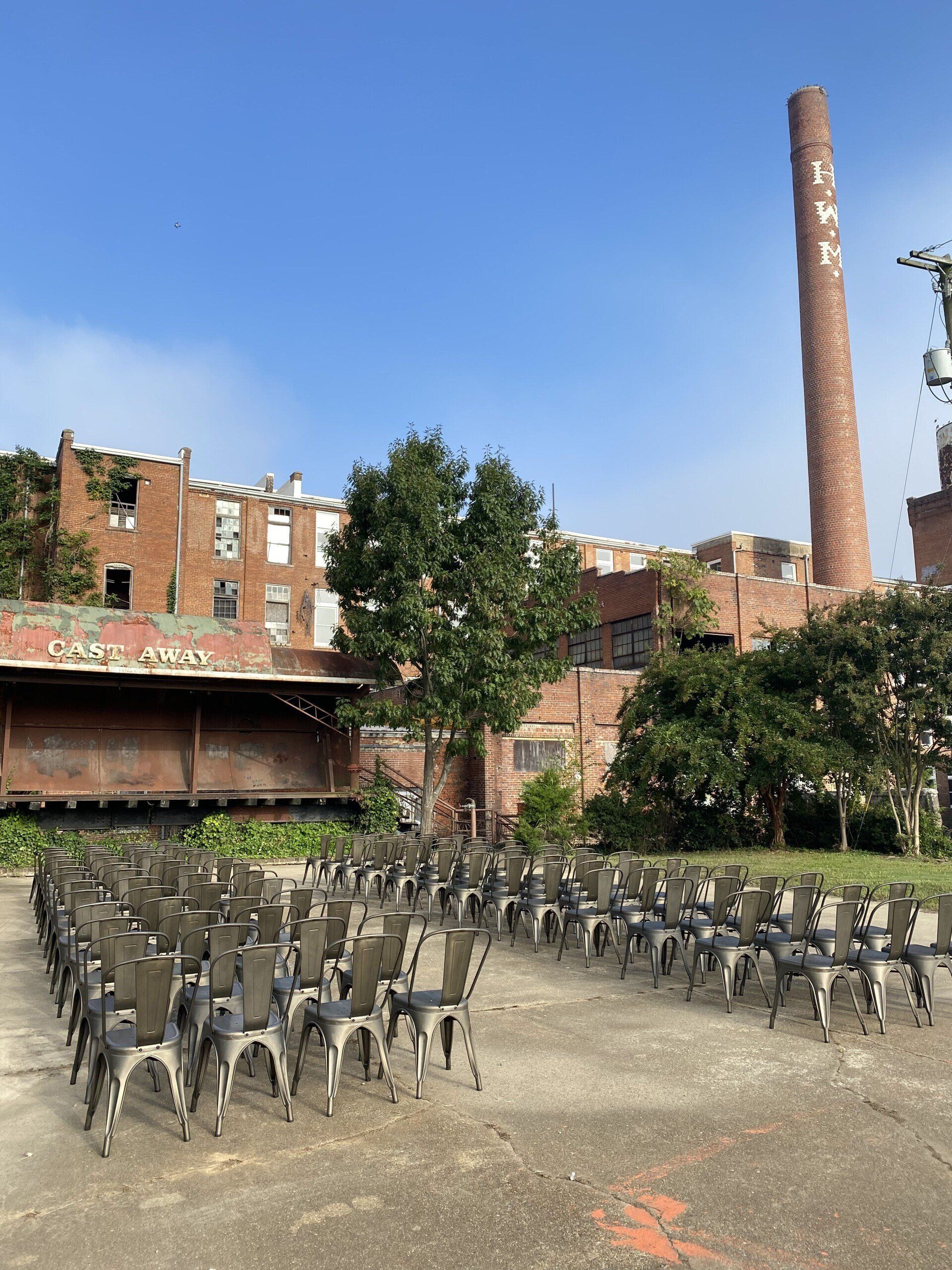 A row of chairs are lined up in front of a brick building.