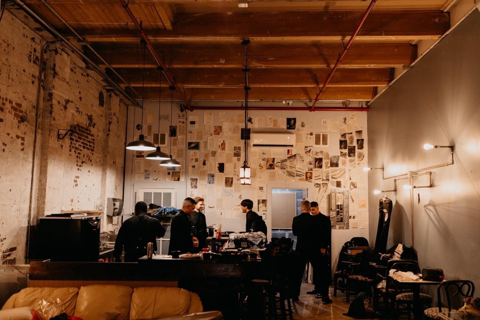 A group of people are standing around a table in a restaurant.