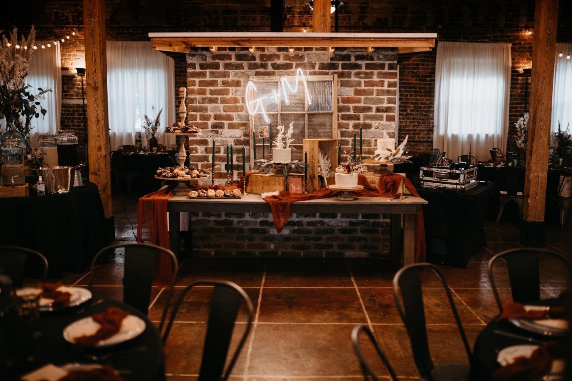 A room with tables and chairs and a brick wall.