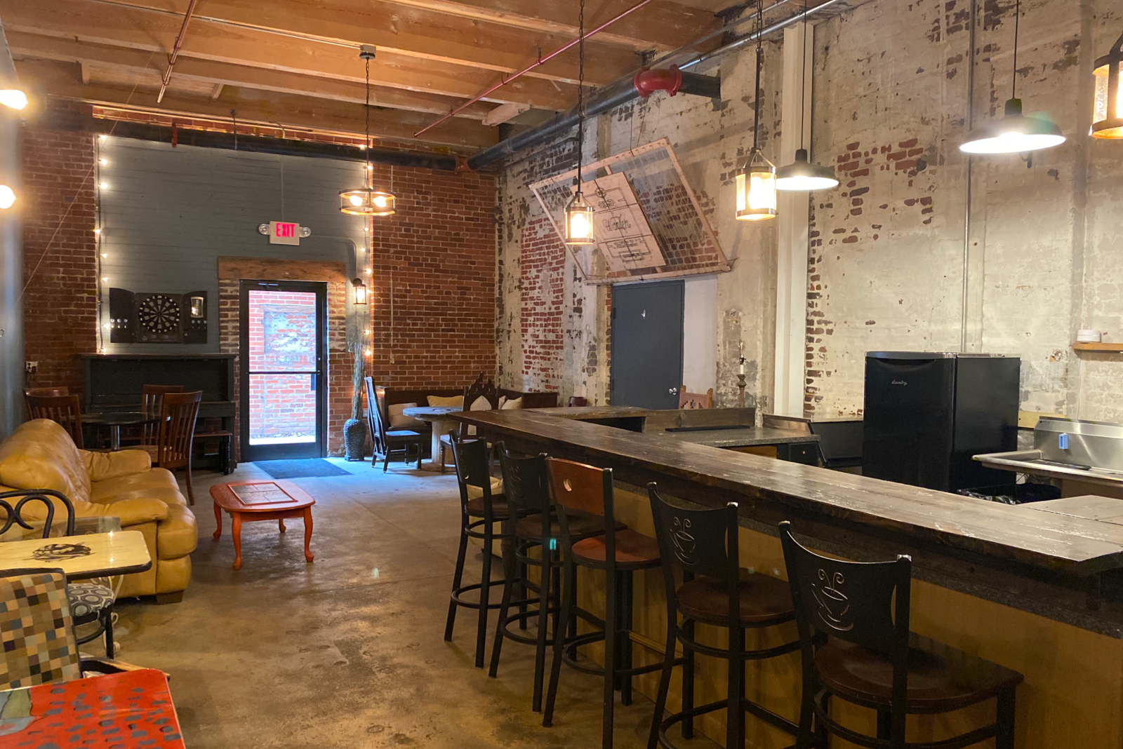 A large room with a bar and tables and chairs