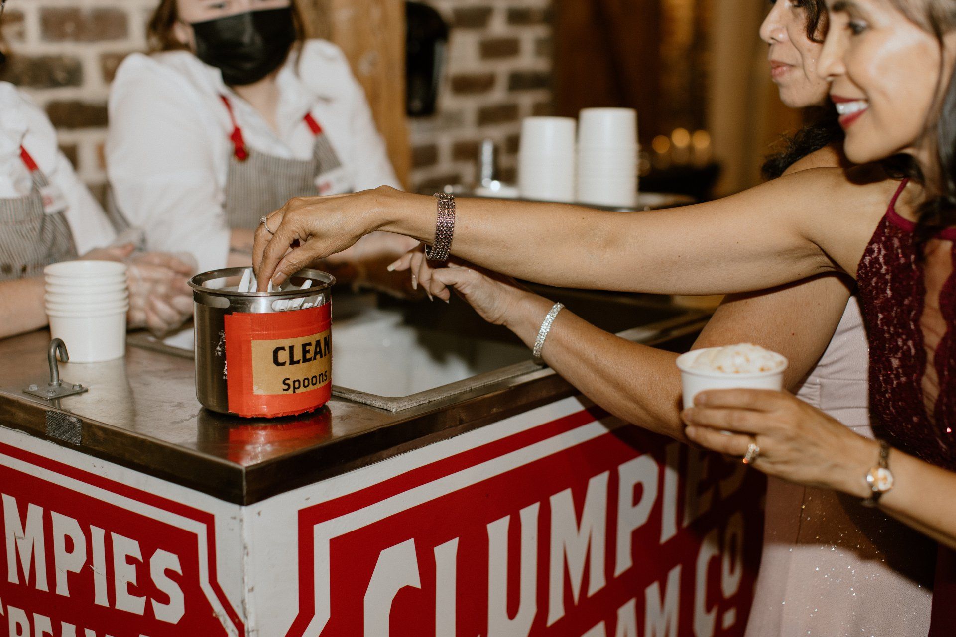 A group of women are sitting at a table eating ice cream.
