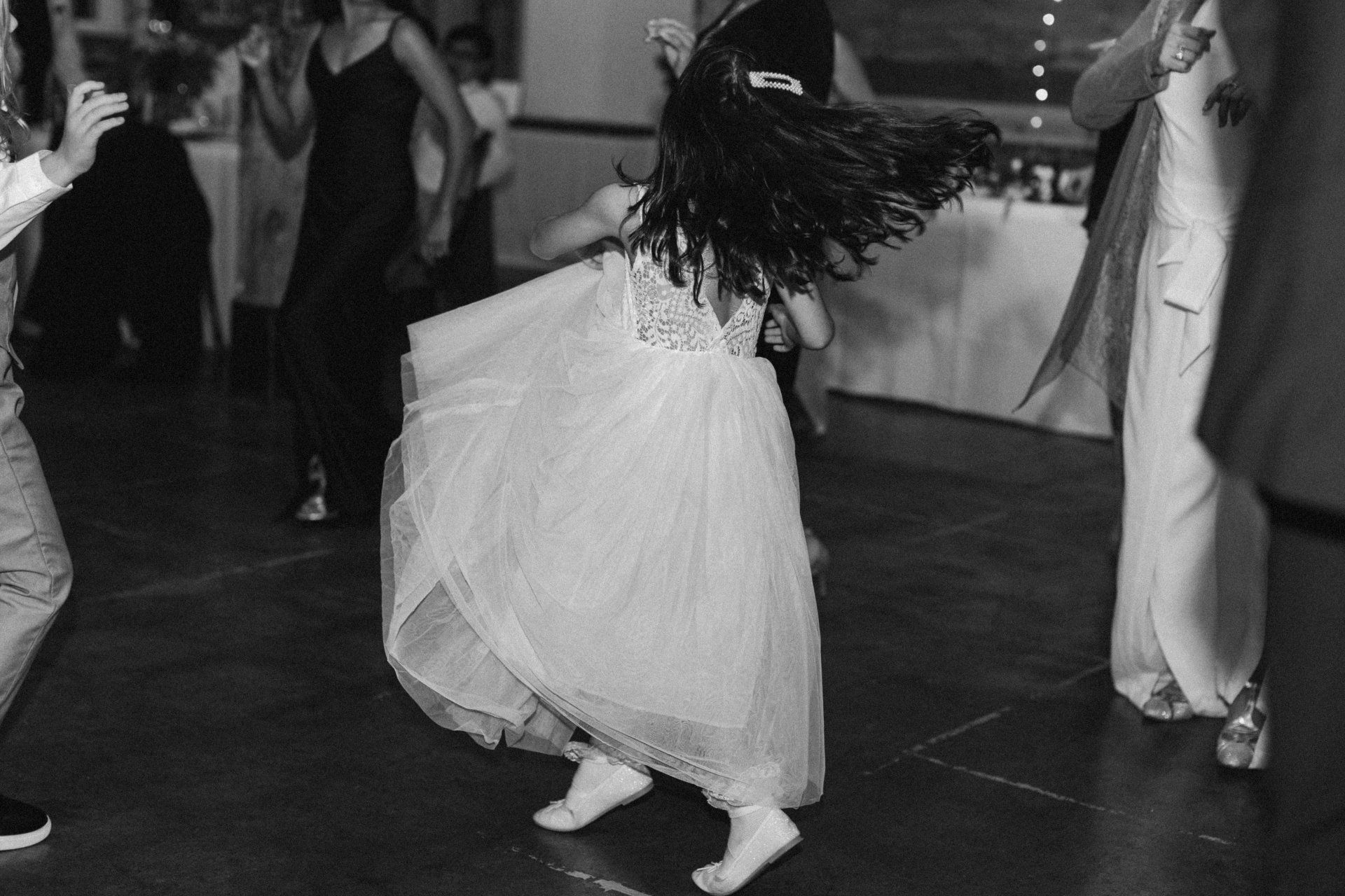 A little girl in a dress is dancing on a dance floor.