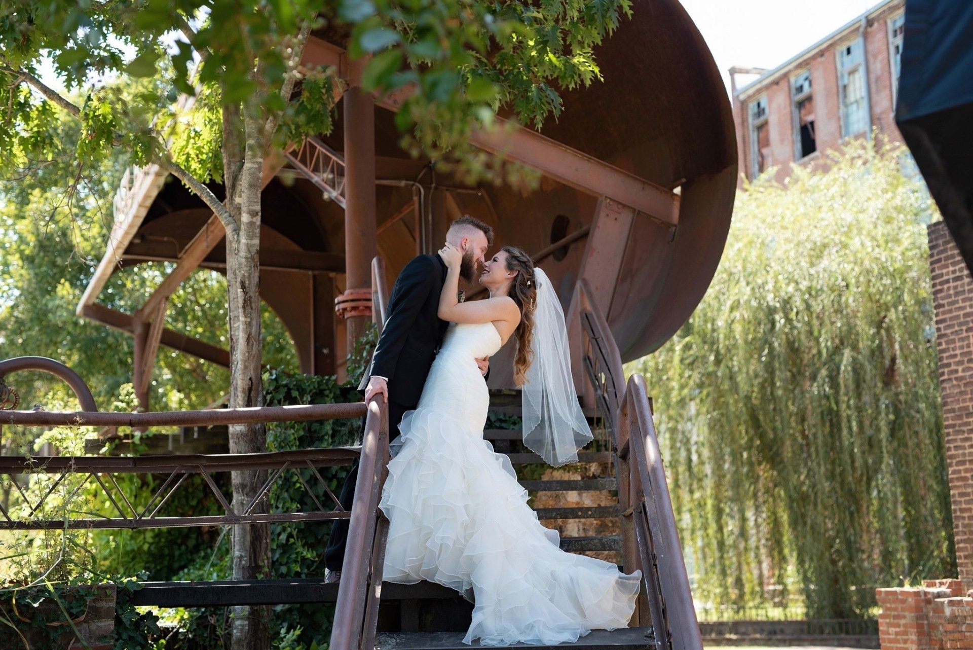 A bride and groom kissing on a set of stairs