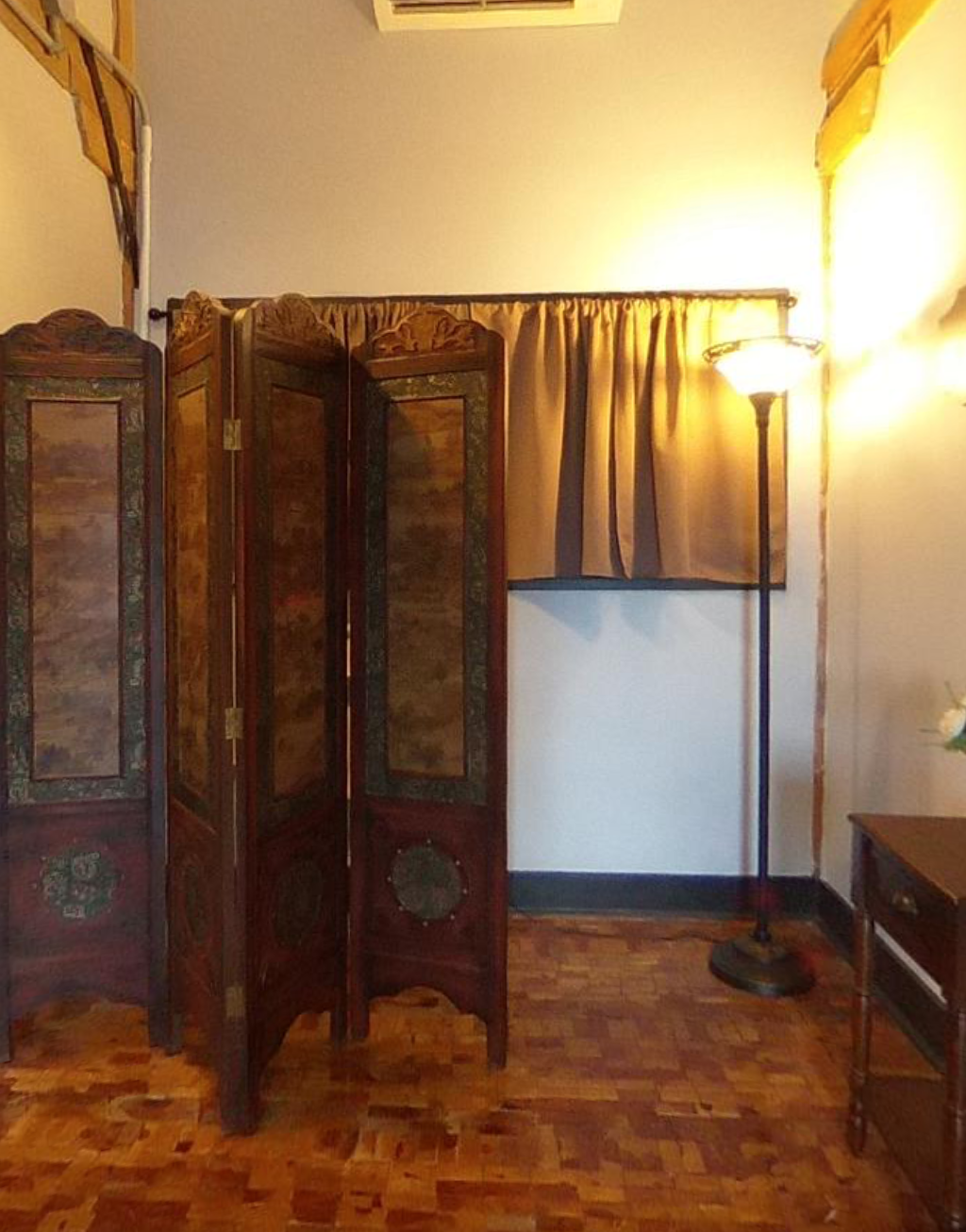 A room with a divider and a lamp on the floor