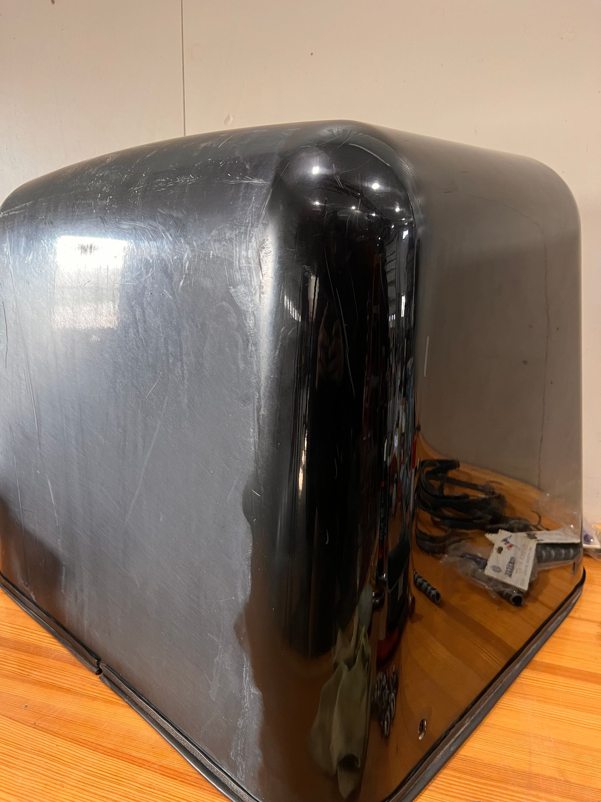 A black cube is sitting on a wooden table