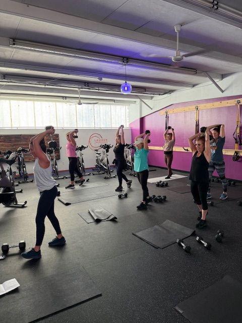 A group of people are doing exercises in a gym