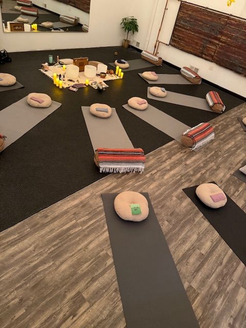 A room with a lot of yoga mats and pillows on the floor