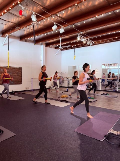 A group of women are doing yoga in a gym