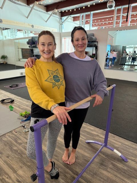 Two women standing next to each other in a gym
