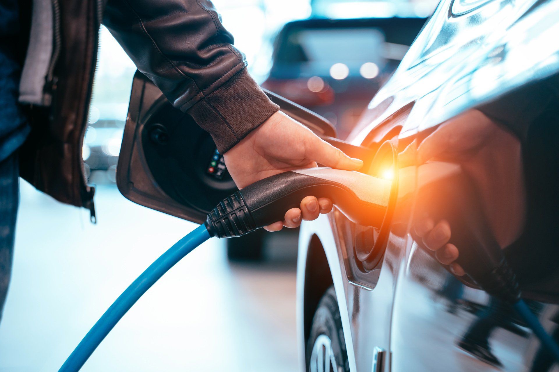 A man is charging an electric car with a charger.