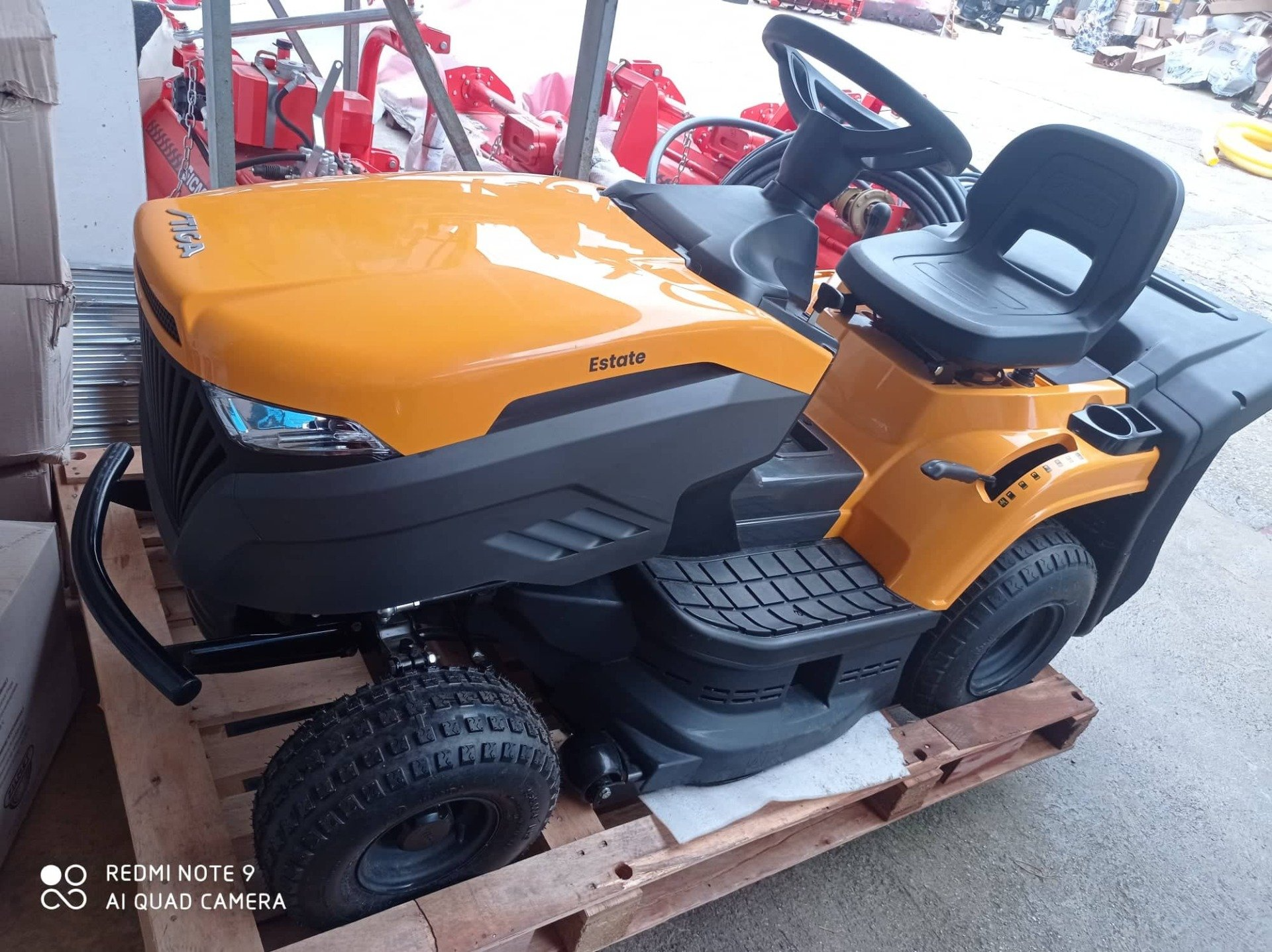 Un tosaerba giallo e nero è appoggiato su un pallet di legno.