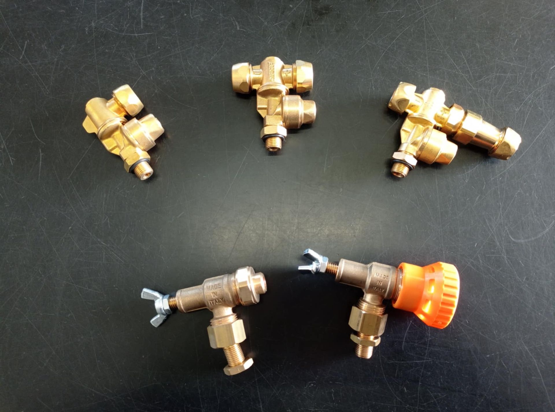 Un mucchio di raccordi in ottone su una superficie nera