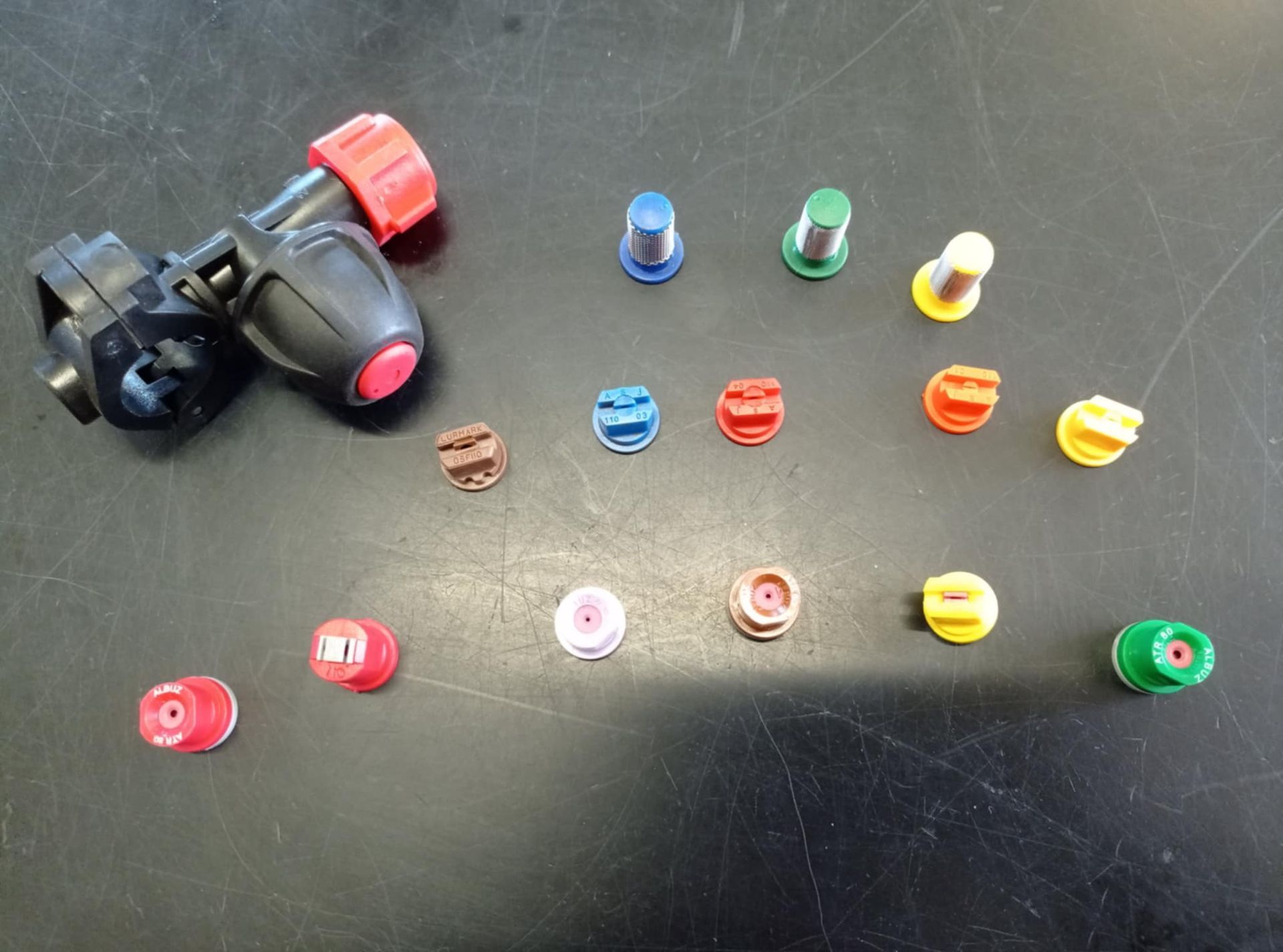 Un mucchio di ugelli spray di diversi colori su un tavolo