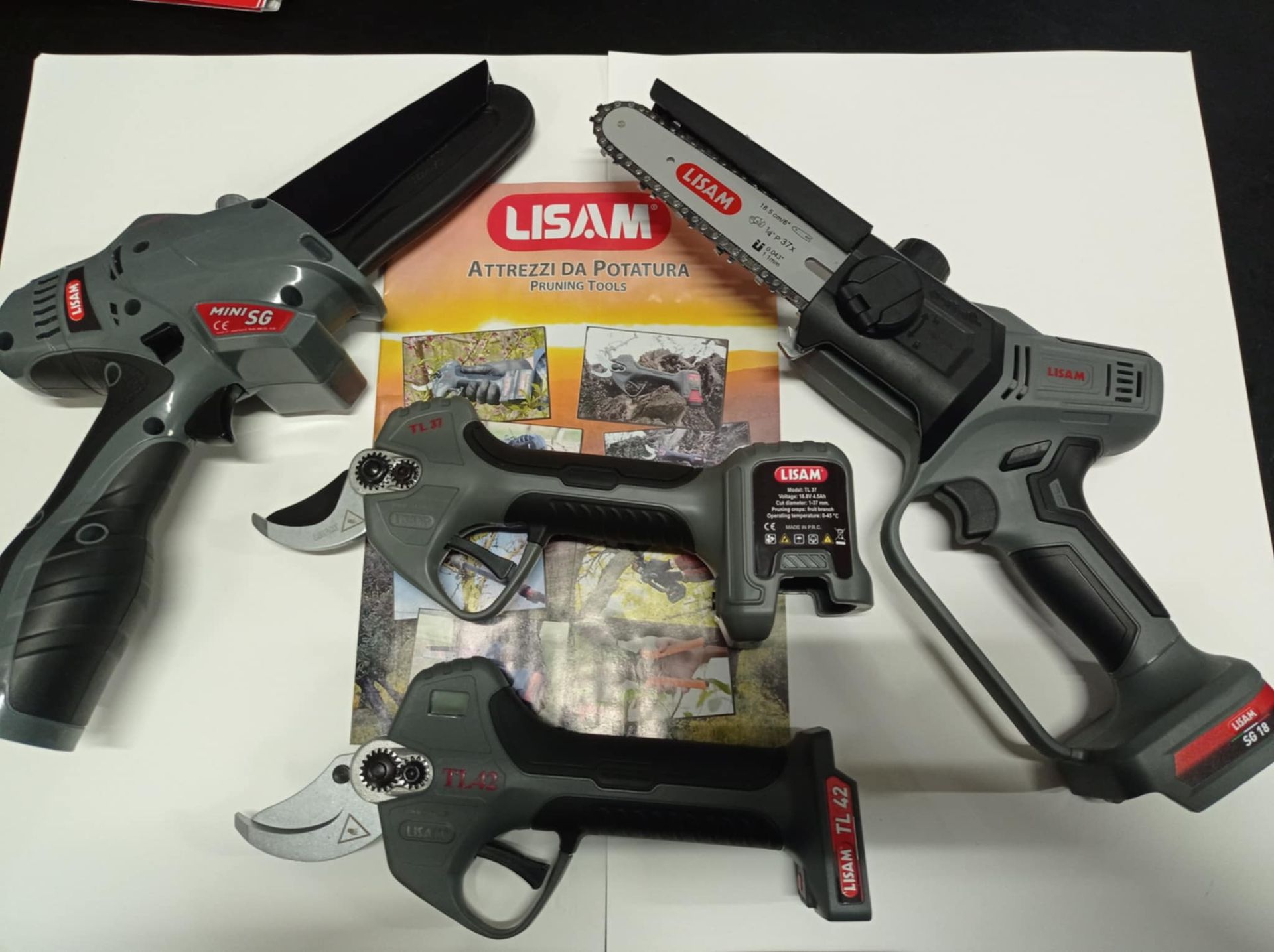 Tre diversi tipi di forbici elettriche sono posizionate una accanto all'altra su un tavolo.