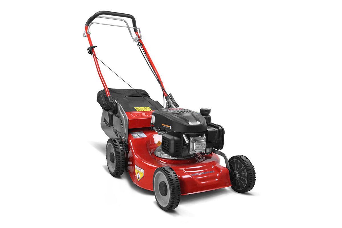 Un tosaerba rosso è appoggiato su una superficie bianca.