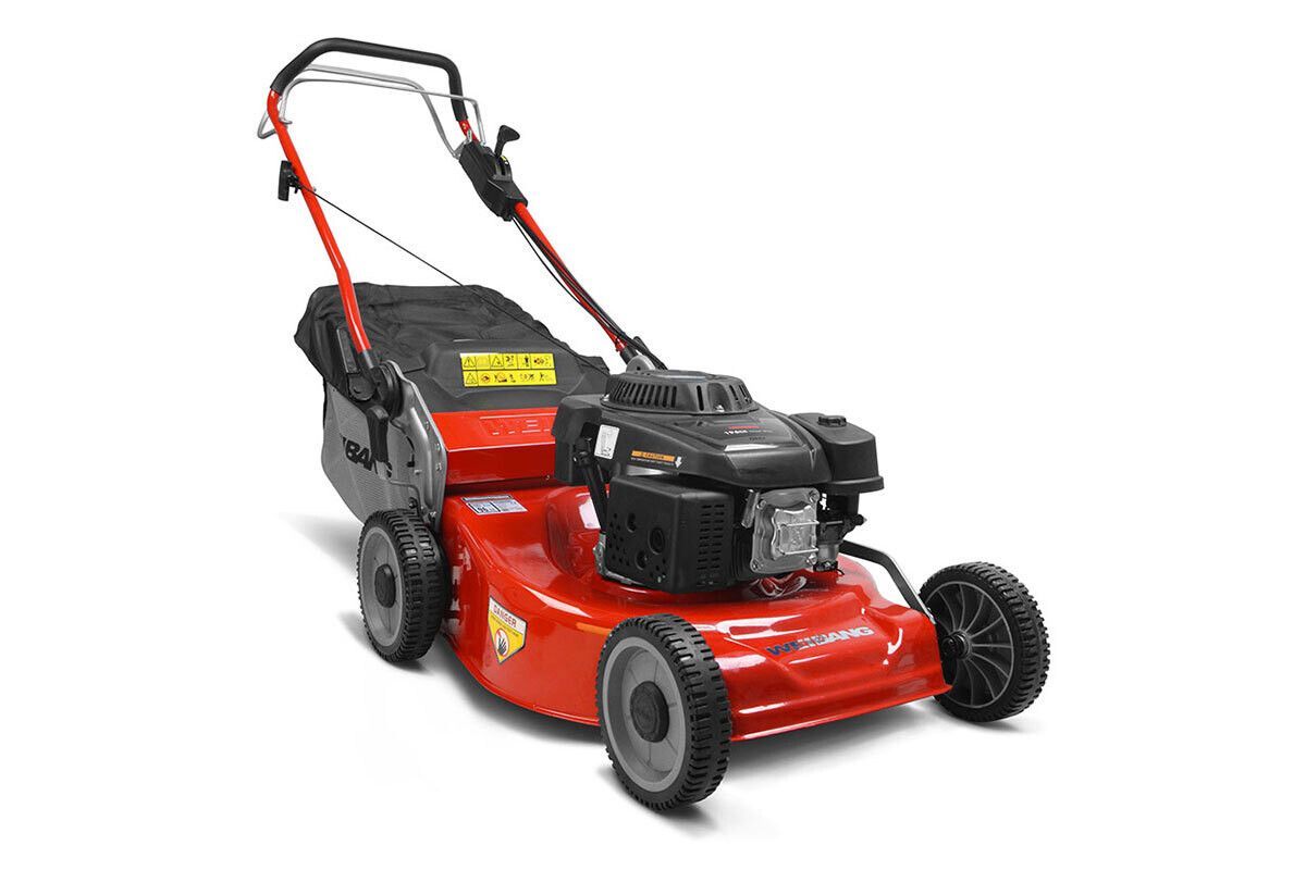 Un tosaerba rosso è appoggiato su una superficie bianca.