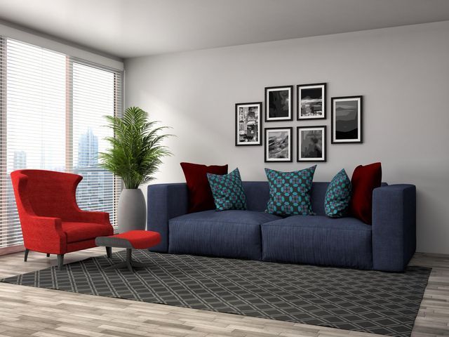 un soggiorno con un divano blu e una sedia rossa