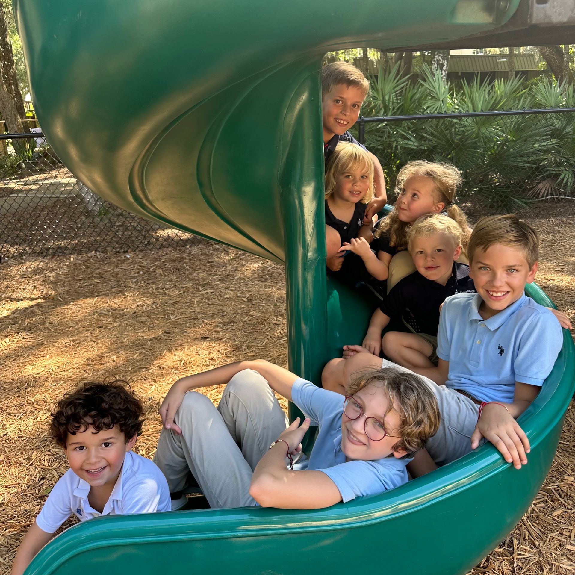 Montessori children of different ages sitting on a slide