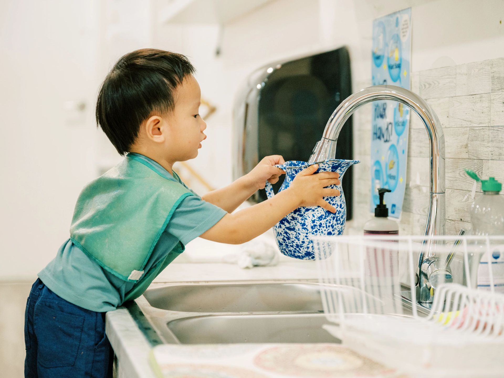 Montessori toddler getting water from the sink