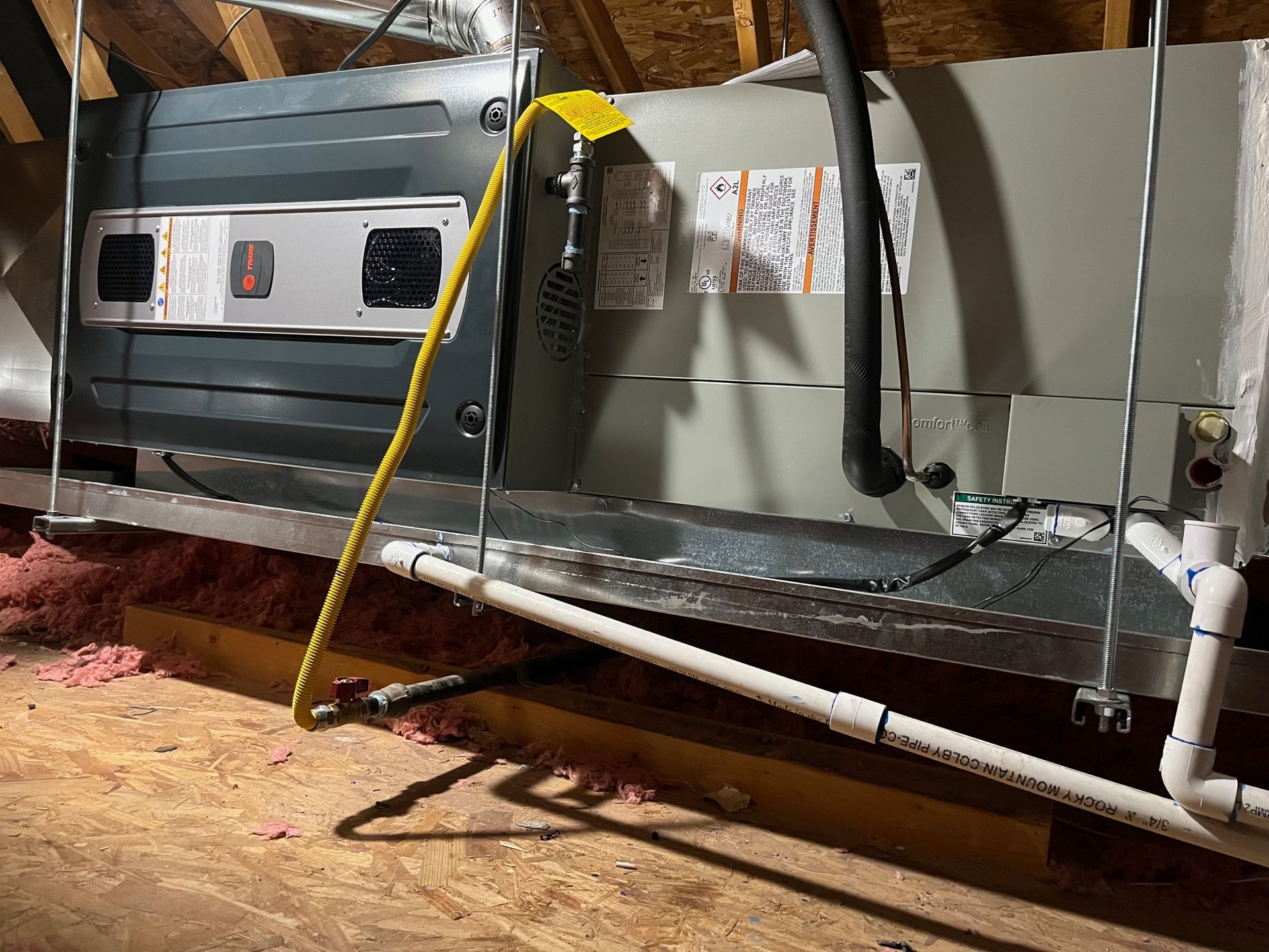 A large air conditioner is sitting in the attic of a house.