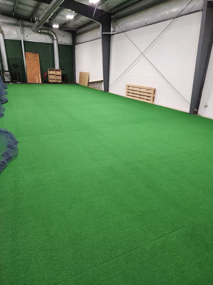 A large room with a lot of green grass on the floor.