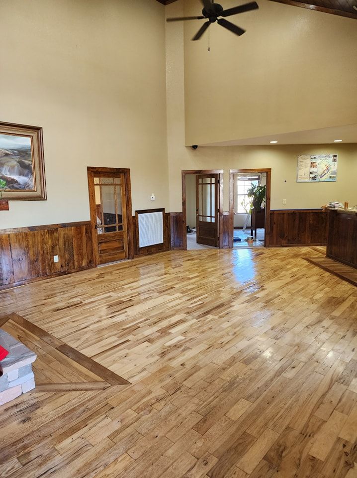 A large room with hardwood floors and a ceiling fan
