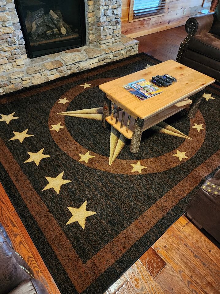 A living room with a rug , coffee table and fireplace.