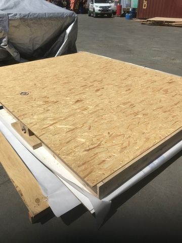A large piece of plywood is sitting on top of a wooden table.