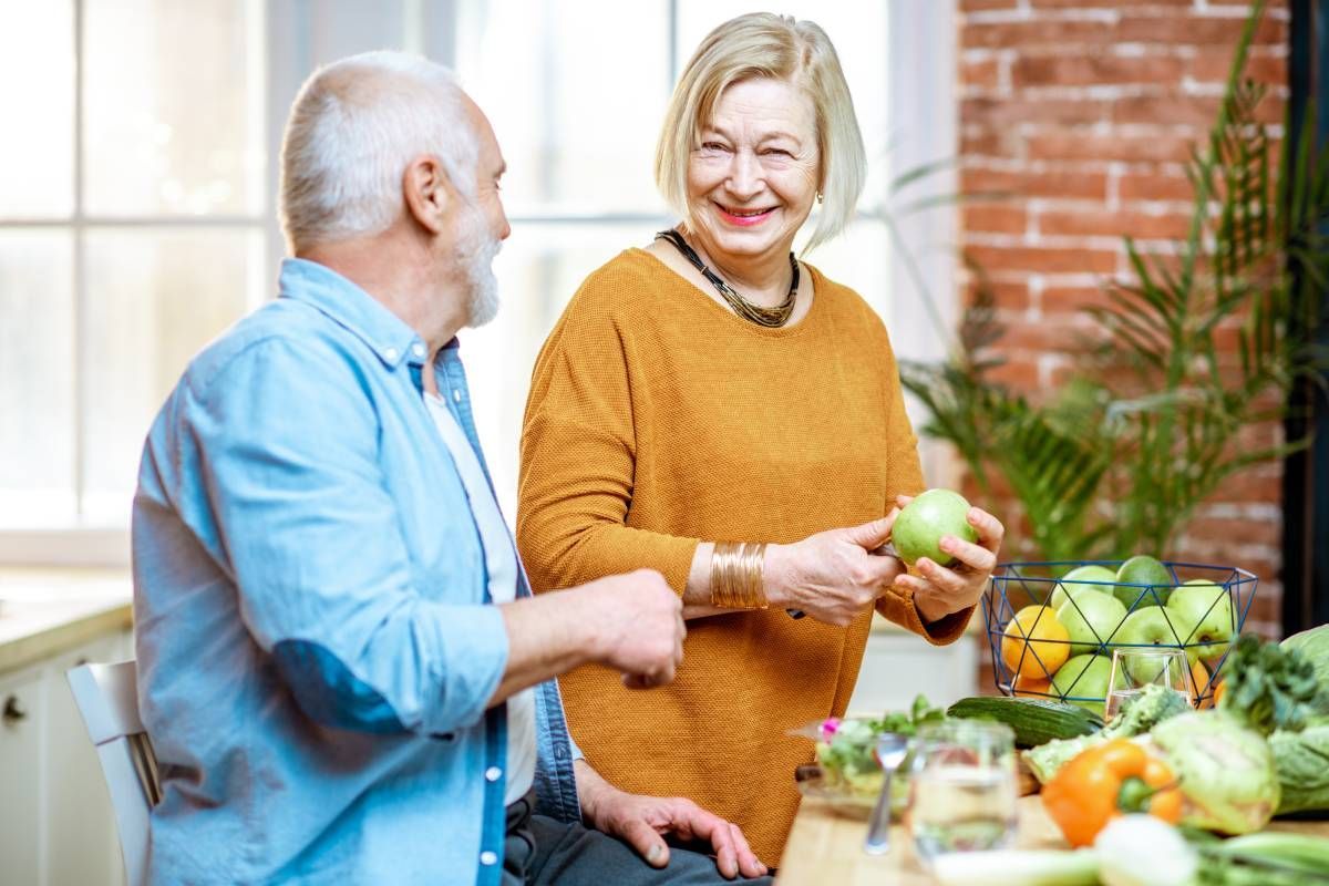 A happy senior couple with healthy food on the kitchen counter near Lexington, Kentucky (KY)