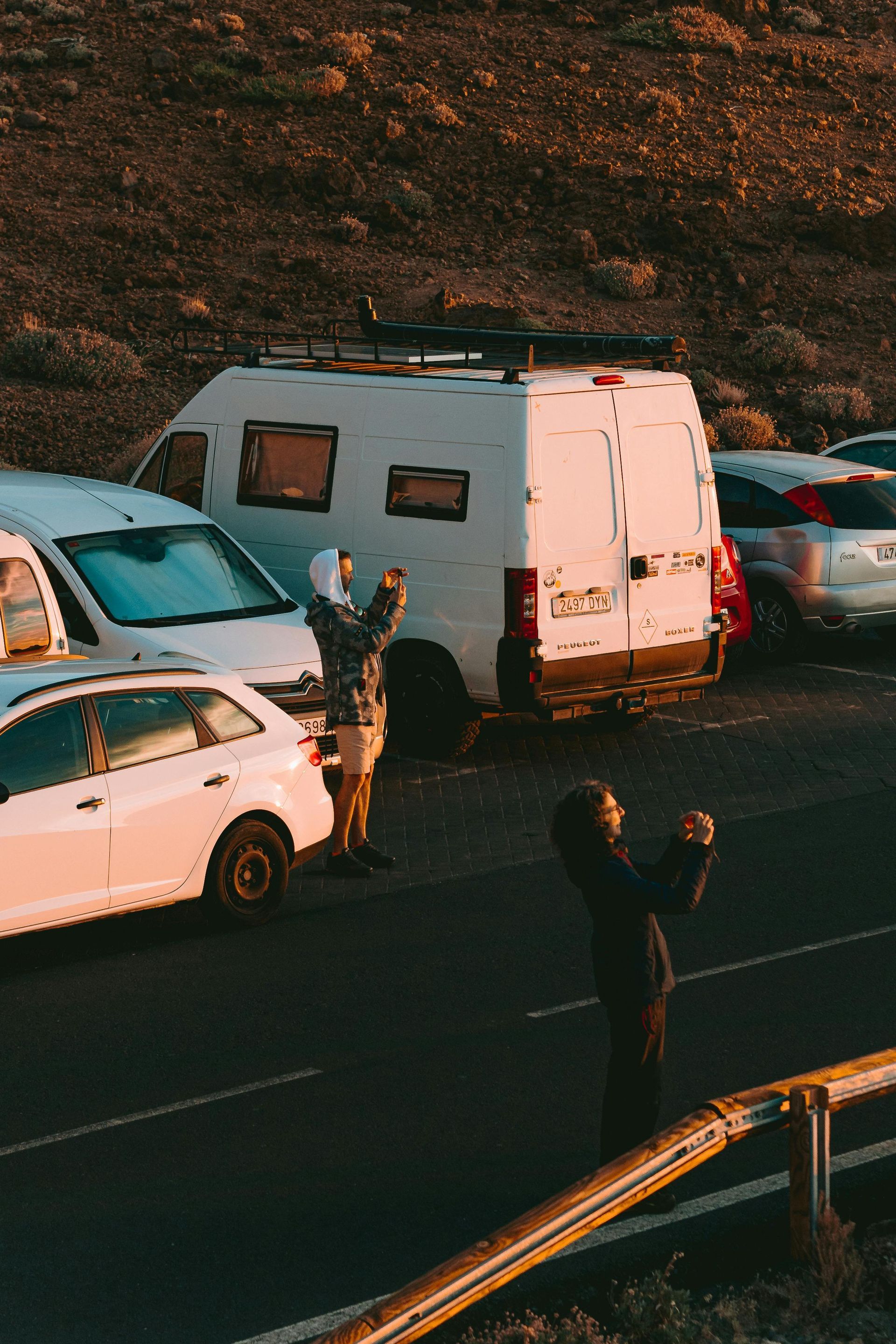 A group of cars are parked on the side of the road.