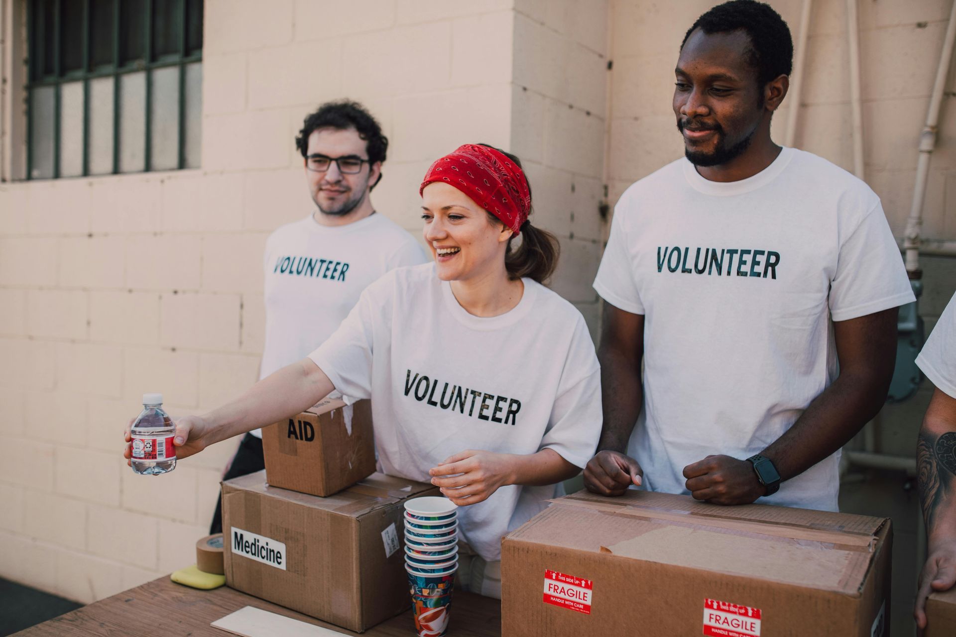 A group of volunteers are standing around a table.