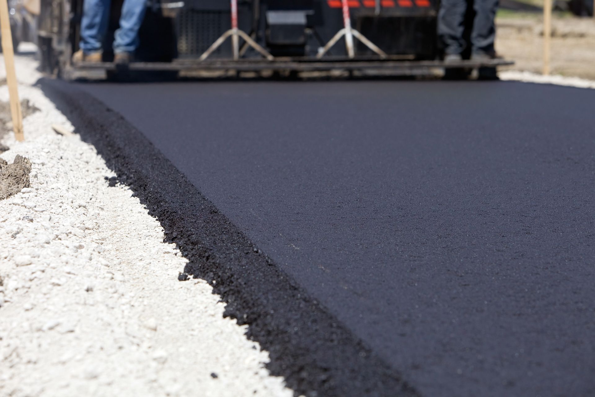 Blacktop smooths the road with Slipform Paver showcasing commercial paving contractor work.