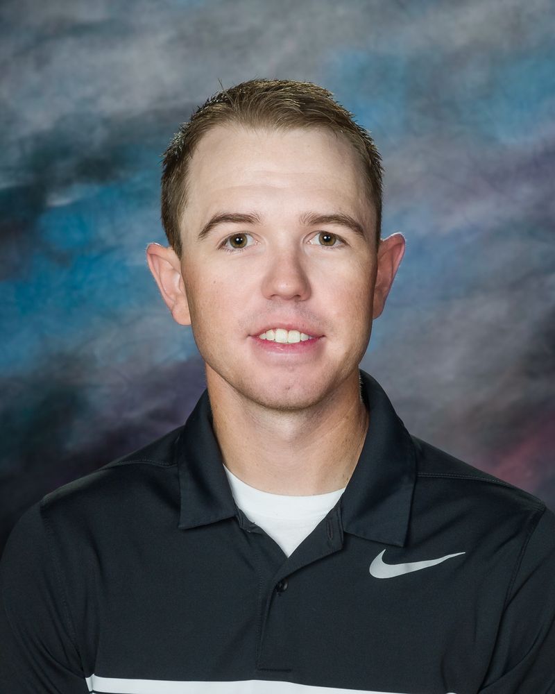 A man in a black nike shirt is smiling for a picture.