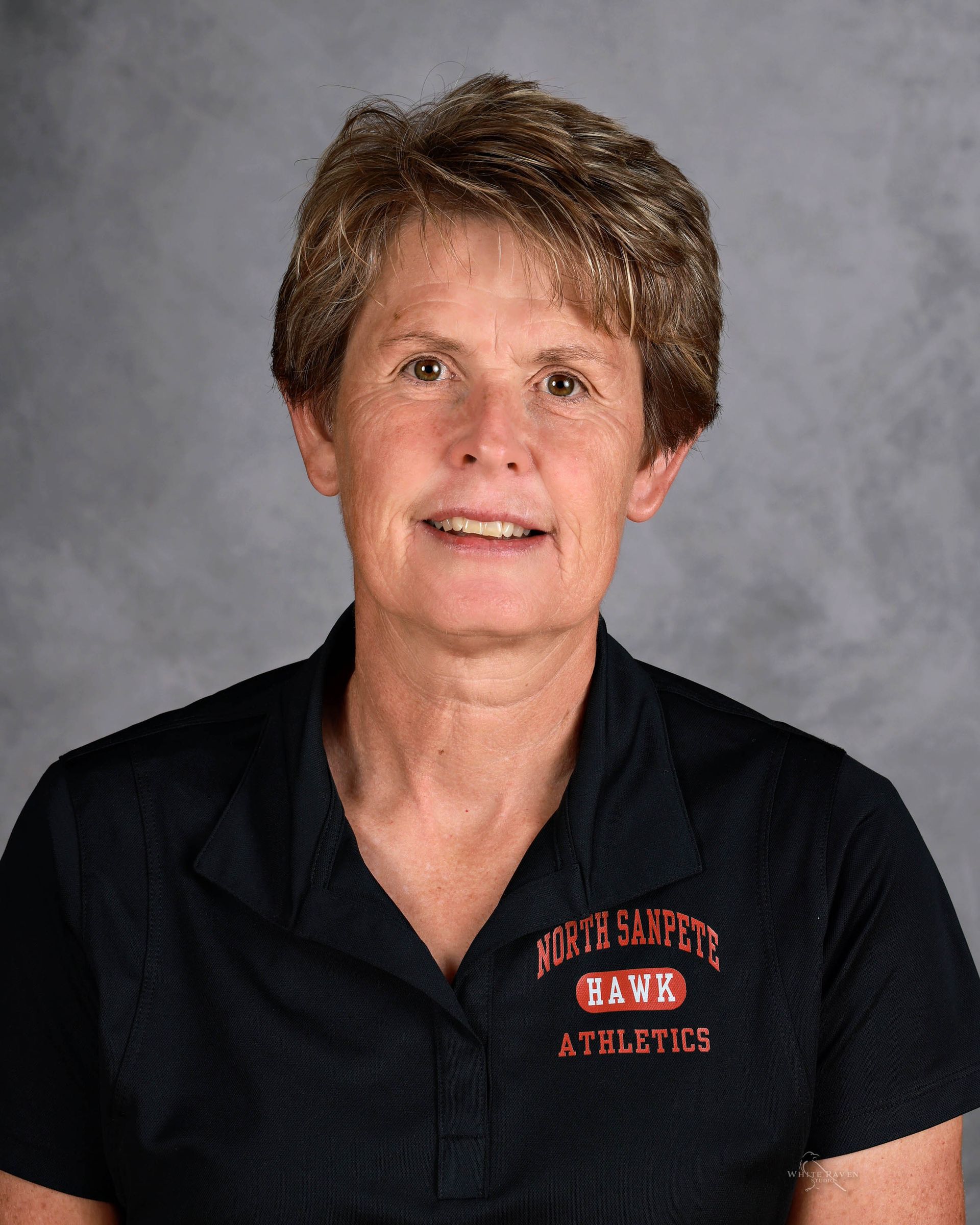 Woman with short brown hair in a black shirt with