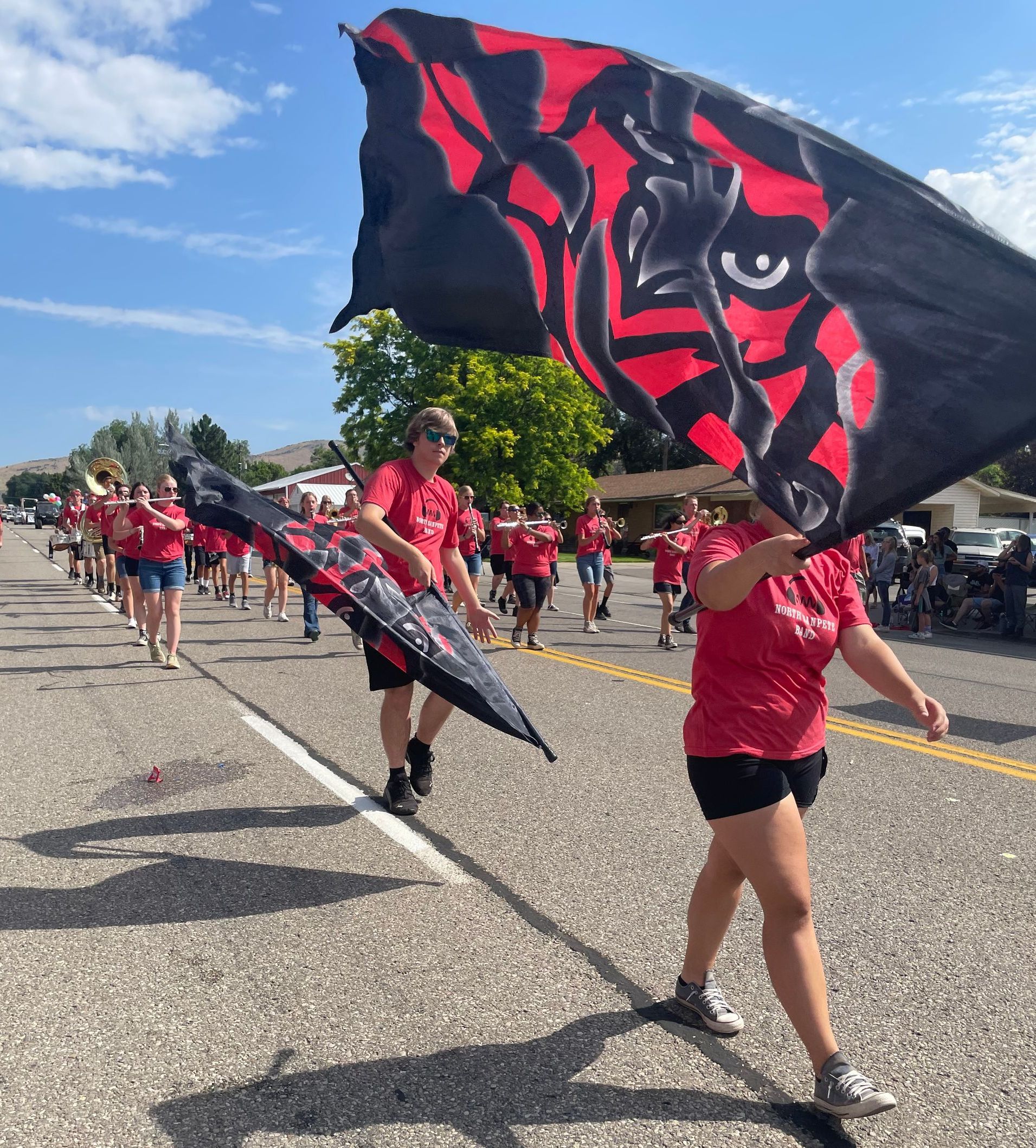 A group of people are marching down a street holding flags.