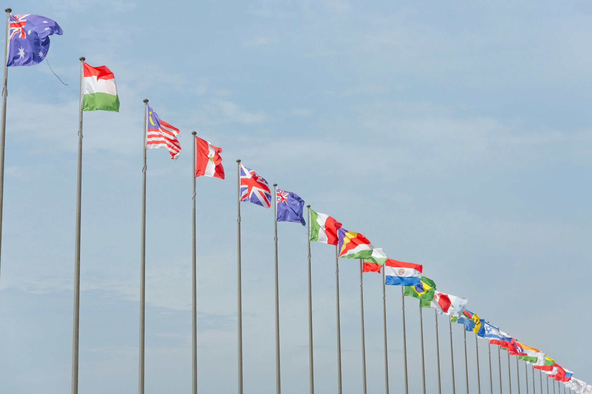 A row of flags from different countries are waving in the wind