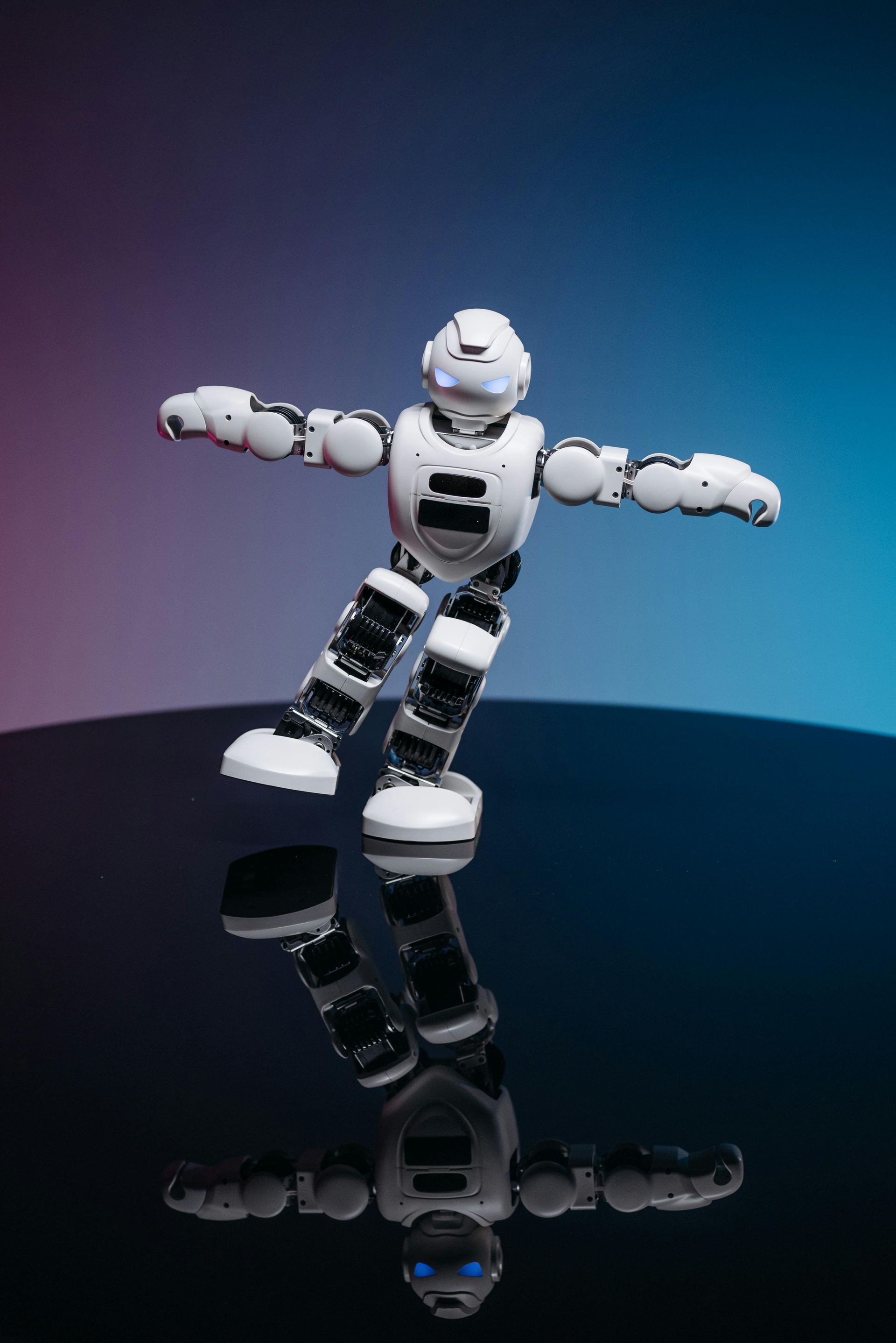A robot is standing on a table with its arms outstretched.