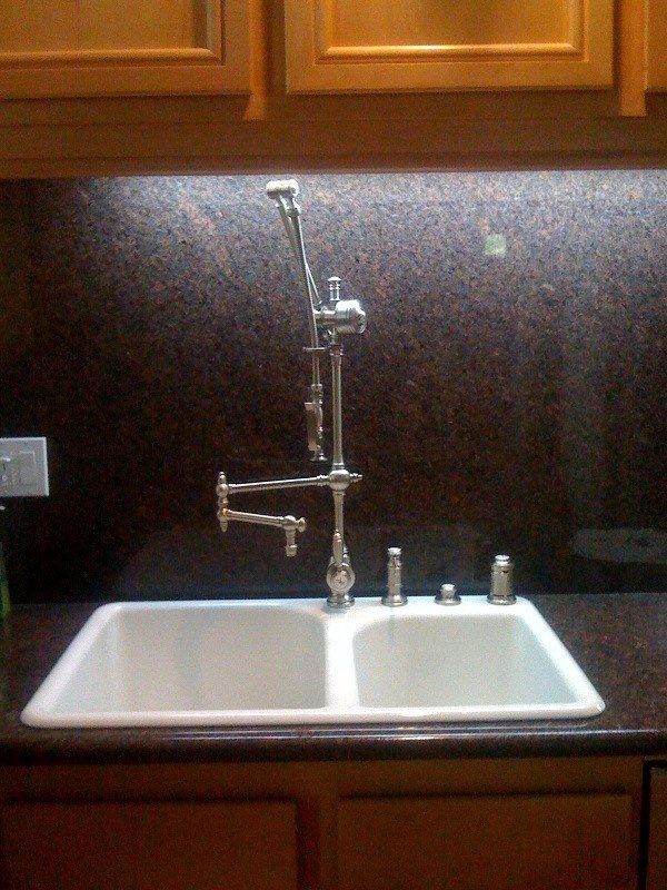 A kitchen sink with two sinks and a faucet