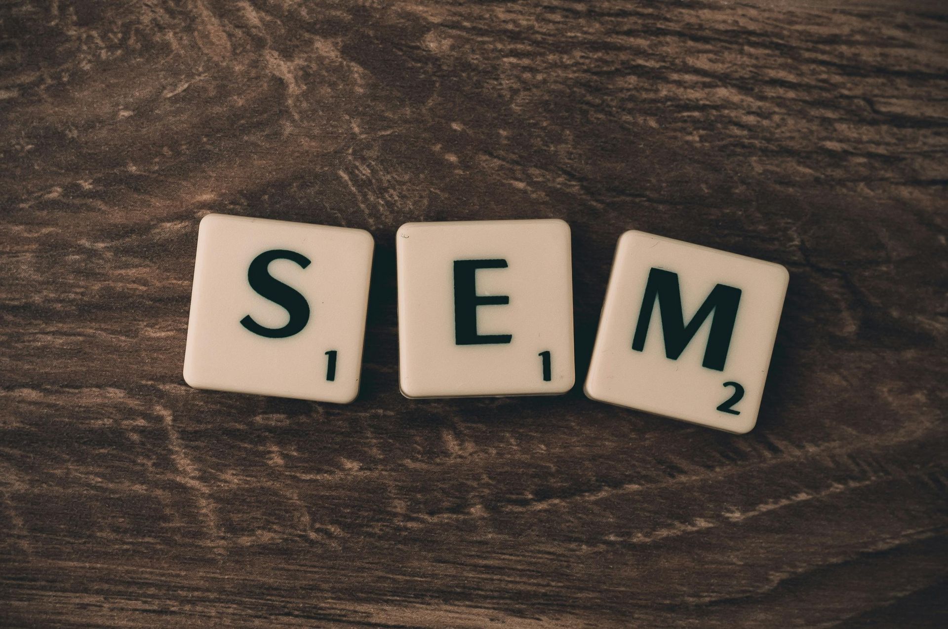 The word sem is written in scrabble tiles on a wooden table