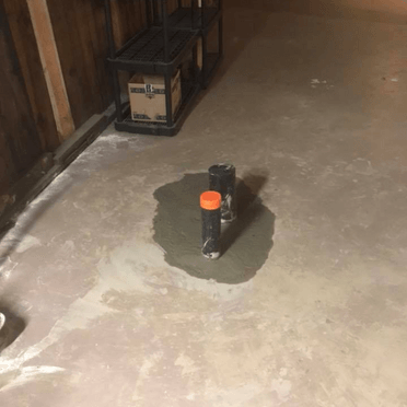 Un sol en béton avec un tuyau au milieu.