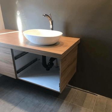 Un lavabo est posé sur un comptoir en bois dans une salle de bain.