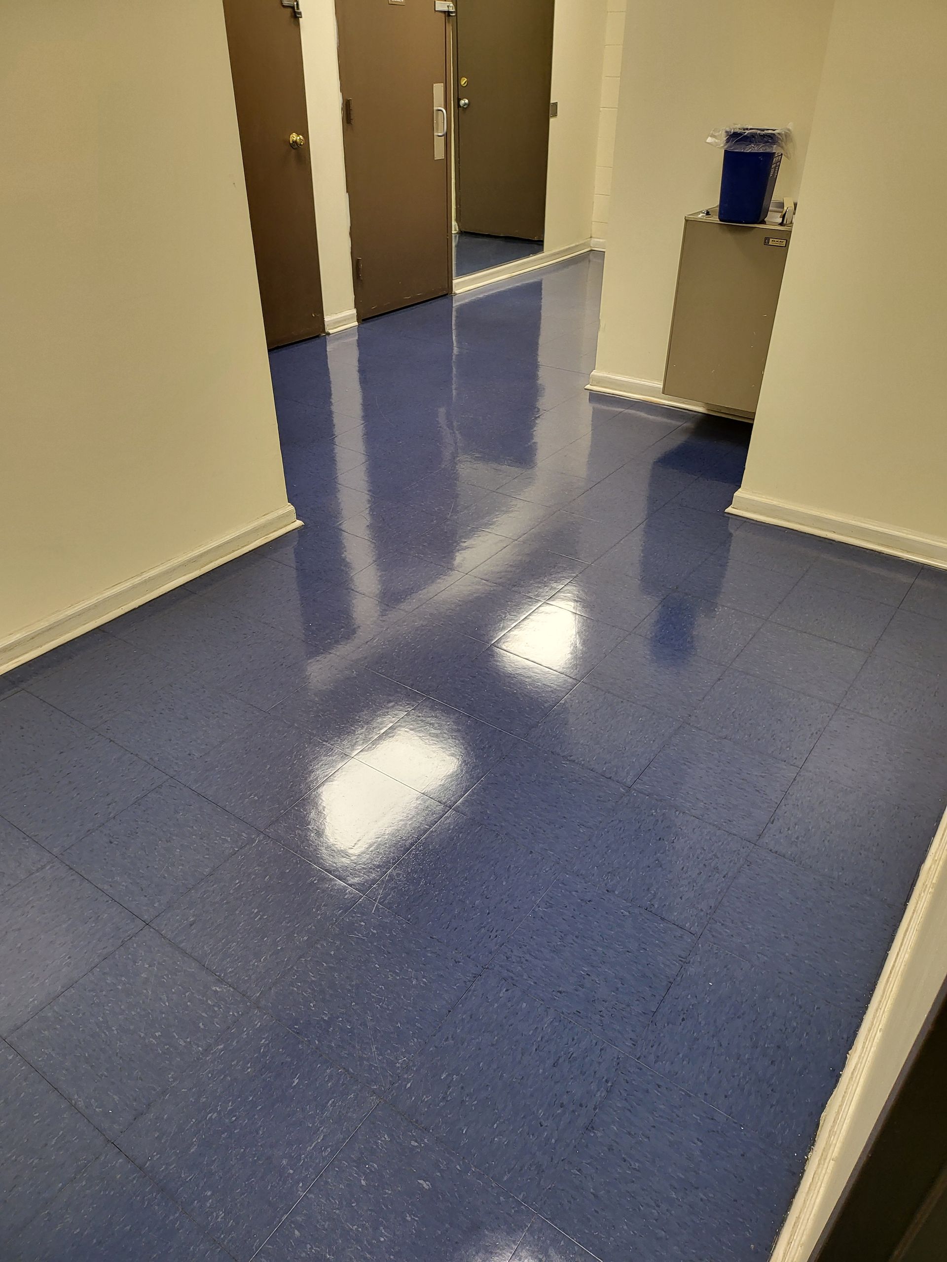 A hallway with a blue floor and white walls